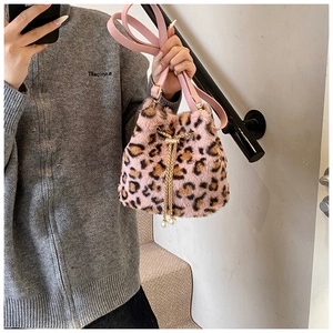 Detailed macro view of pink leopard faux fur bucket bag with white pearl drawstring charms