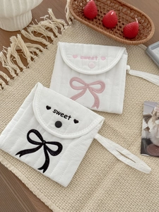 Detailed view of quilted fabric pouch with embroidered sweet text and bow design