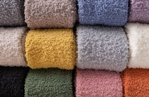Macro shot of colorful coral fleece socks neatly rolled in a twelve-pair set bundle