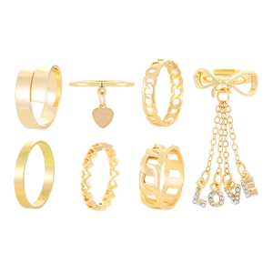 Detailed view of 7-piece gold ring set featuring heart, bow, and rhinestone LOVE charms