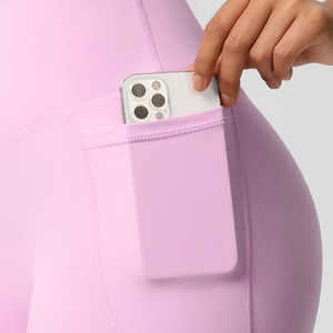 Detail of pink high-waisted yoga shorts featuring a functional side phone pocket