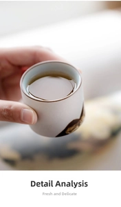 Detail of a handmade ceramic tea cup with mountain ink wash texture and smooth warm tea