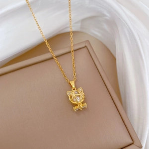 Macro view of golden cat pendant with crystal stone and diamond accents on silk fabric