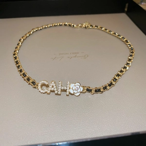 Detail of flower necklace with gold-plated chain, pearls, and black leather cord