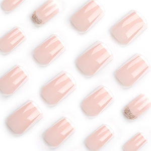 French tip press-on nails with nude pink base and gold glitter gradient accents