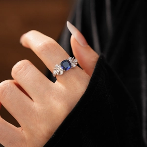 Détail d'une bague feuille avec un zircon bleu carré et des pierres scintillantes