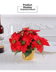 Red poinsettia Christmas centerpiece with gold pot and pinecones on a festive dinner table