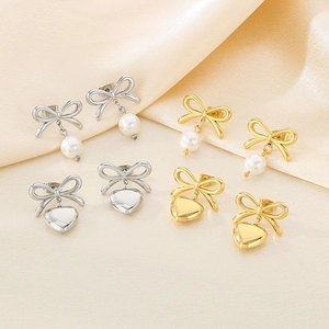 French bow earrings set with pearls and metal hearts in gold and silver finishes