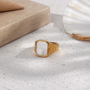 Detail of vintage gold ring with white square shell inlay and strap-style chain band