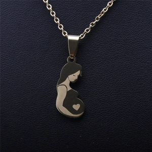 Close-up of golden silhouette pendant depicting a pregnant woman with a heart