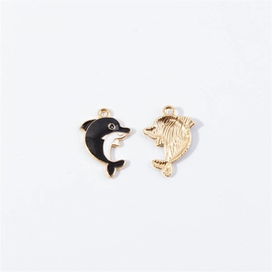 Detailed view of two gold dolphin charms with black and white enamel finish for DIY jewelry