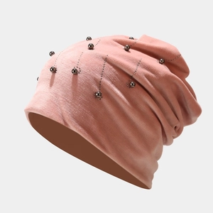 Detail of pink velvet beanie with metallic pearls and rhinestone vertical stripes