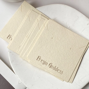 Detailed view of cream textured jewelry display cards for earrings and necklaces