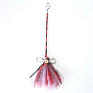 Detail of Halloween witch broom with red mesh, golden buckle and silver bow hanging decoration