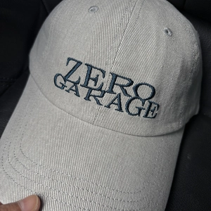 Macro detail of navy ZERO GARAGE embroidery on grey cotton canvas baseball cap