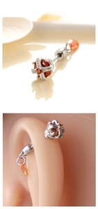 Detailed view of silver crown barbell earring with red crystal on silicone ear model