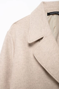 Détail du revers et de l'épaule d'un manteau en laine beige montrant la texture du tissu