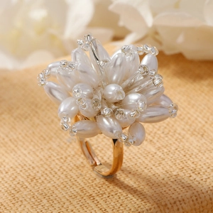 Macro detail of a handmade floral ring with white pearls and adjustable gold band