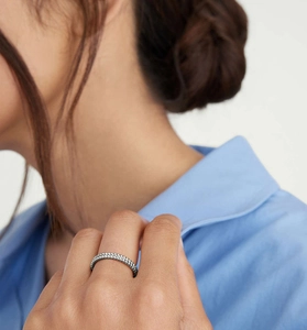 Detail view of a double-row silver bead ring worn by a model against a blue shirt background