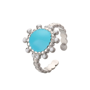 Close-up of silver sun-style ring with blue center and white dotted pattern detail
