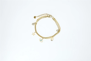 Close-up of golden layered bracelet featuring star charms and the evil eye motif