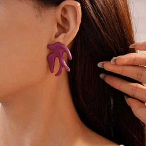 Gros plan de boucles d'oreilles vintage violettes avec bords dorés sur le mannequin