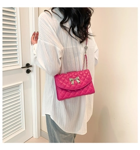 Détail du sac bandoulière matelassé rose avec boucle nœud argenté porté à l'épaule