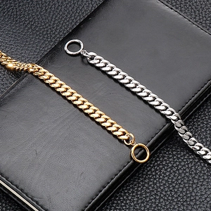 Detailed shot of silver and gold Cuban link bracelets with OT buckle on black leather