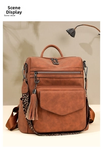 Detail of vintage brown backpack with fringe tassel and leopard print shoulder strap