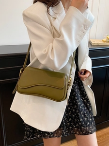 Olive green vintage flap shoulder bag with adjustable gold buckle shown on model