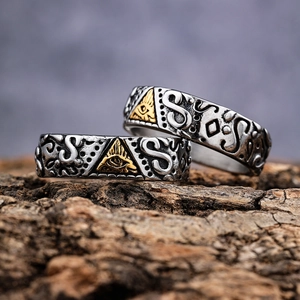 Vintage stainless steel ring with Eye of Horus relief on a textured wood surface