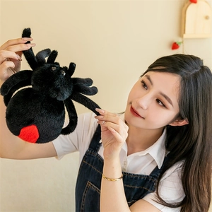 Detailed view of large black plush spider with red belly spot held by a woman