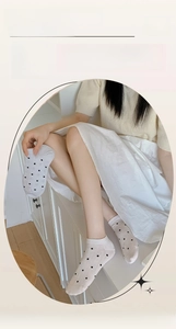 Detailed macro view of white low-cut boat socks with black polka dots and breathable mesh fabric