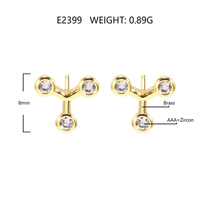 Macro detail of Y-shaped gold earrings with AAA+ zircon stones on high-grade brass