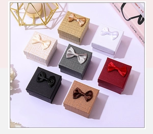 Detailed view of jewelry gift boxes in multiple colors with satin ribbon bows on top