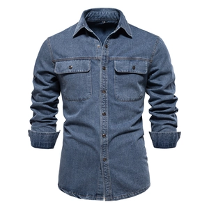 Détail de chemise en jean délavé avec doubles poches de poitrine et boutons métalliques