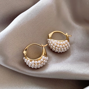Elegant gold-plated hoop earrings with dense pearl inlay on champagne silk background