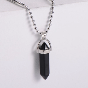 Detailed view of a hexagonal black onyx bullet pendant on a silver beaded chain