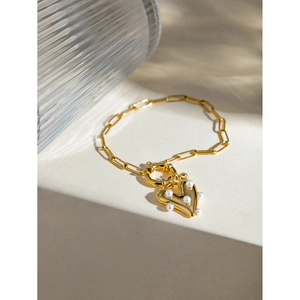 Detail of 18k gold heart pendant with pearls on paperclip chain with OT toggle clasp