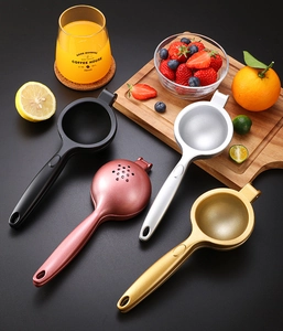 Zinc alloy manual citrus juicers in black, pink, silver, and gold on a dark background