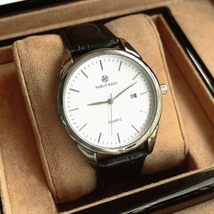 Detail of quartz man watch with silver case and white dial in a brown gift box