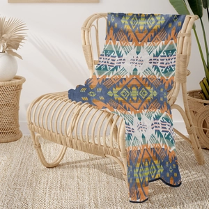 Close-up of bohemian knit blanket with geometric tribal patterns on a rattan chair