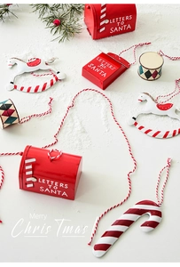 Flat lay of metal Christmas ornaments with red mailbox, rocking horse and drum on snow