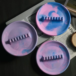 Détail du plateau à bijoux rond en résine marbrée avec rainures sur bois et papier