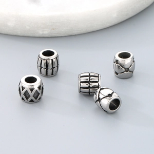 Close-up of five silver vintage titanium steel beads with carved texture for jewelry making