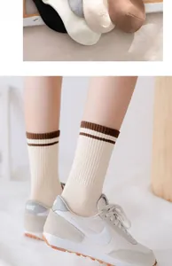 Detail of ribbed knit cotton mid-calf socks with sporty stripes and elastic texture