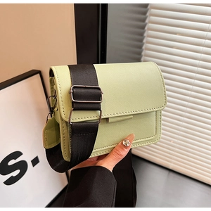 Detail of light green PU leather small square bag with wide black strap and silver metal hook
