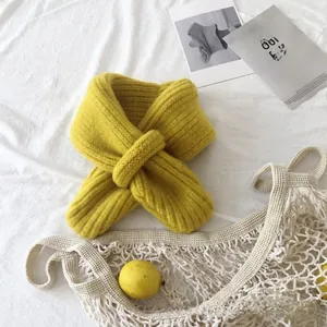 Close-up of bright yellow thick ribbed knit scarf for babies with cross-hole design