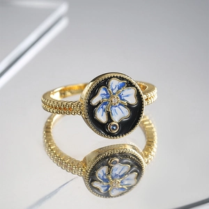 Vintage gold ring with black enamel, blue floral patterns and micro-set zircon accents