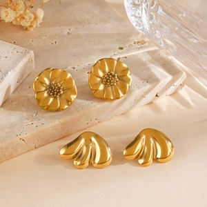Elegant gold flower and petal stud earrings displayed on minimalist stone texture